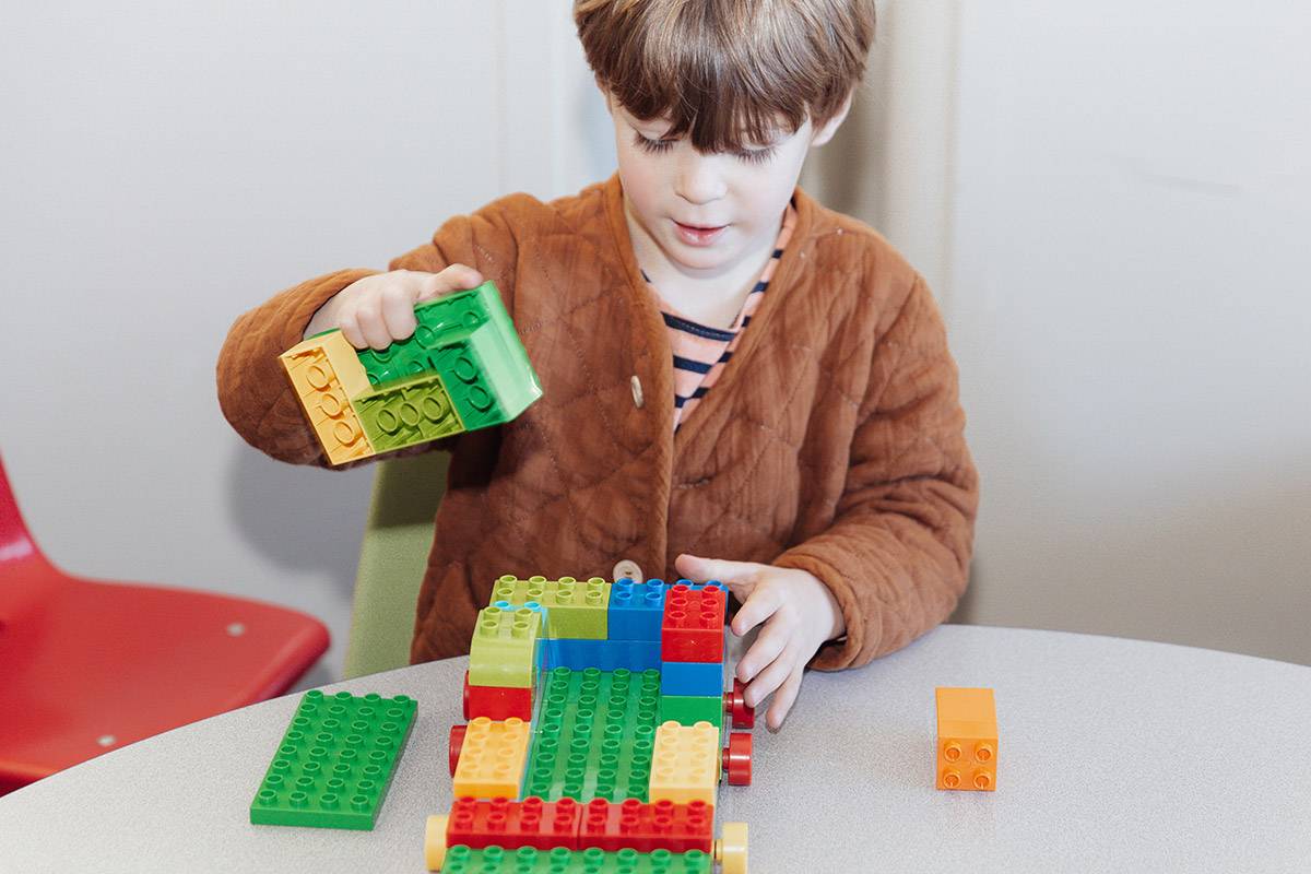 Preschool age boy playing with building blocks. 