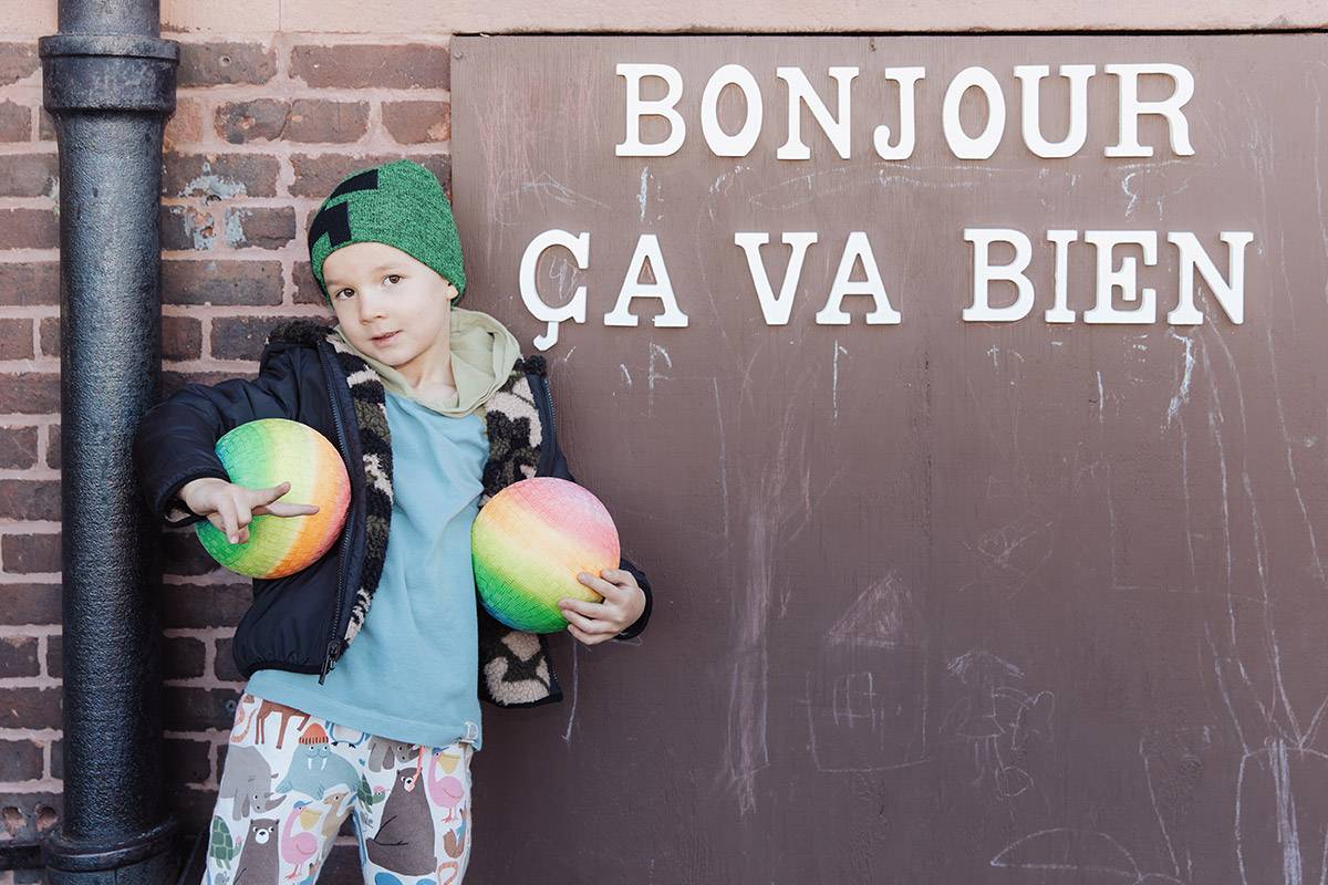 Preschool boy in front of Bonjour Ca Va Bien sign